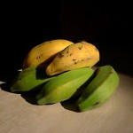 Green and gold ripening bananas.