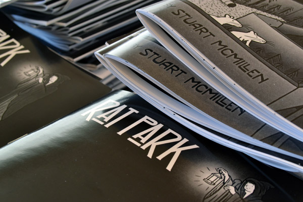 Cryptically-framed shot of the Rat Park cover art. I wanted to keep it slightly mysterious so that the design remained a secret until launch day! Photograph of comic book cover with shallow depth of field. Rat Park comic by Stuart McMillen. Artist's name in focus.